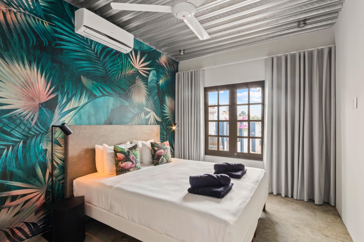 Schlafzimmer 2 mit Kingsize-Bett, Palmenblatt-Tapete, Klimaanlage und Deckenventilator