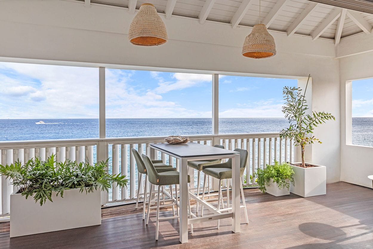 Balcony with dining table and lounge area by the sea