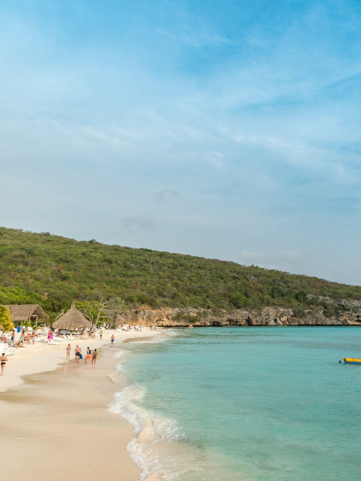 Der weiße Strand von Playa Cas Abao mit türkisem Wasser und Palapas