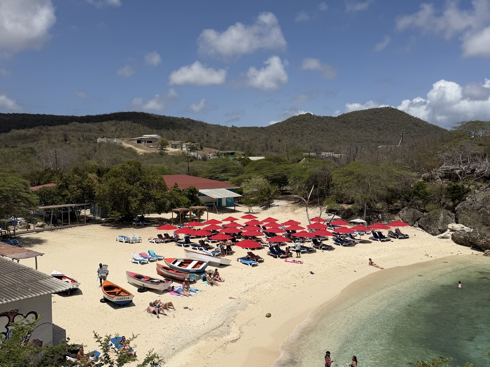 Weißer Strand mit türkisem Wasser und Palapas auf Curaçao